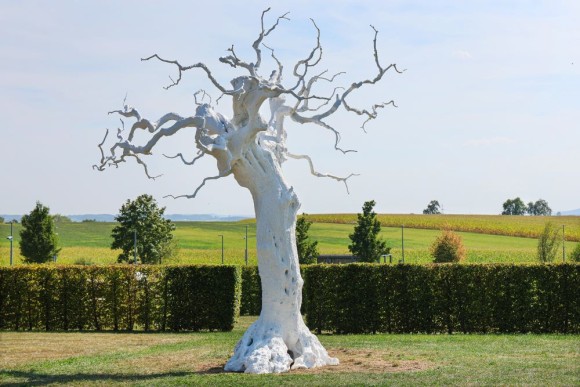 Das Bild zeigt eine Skulptur von Ugo Rondinone im Skulpturengarten des Museum Würth 2. Der Künstler hat einen weißen Baum aus Aluminium vor die weite Landschaft Hohenlohes gesetzt. 